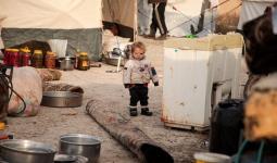 طفل يقف في عراء خيمة النزوح شمال سوريا