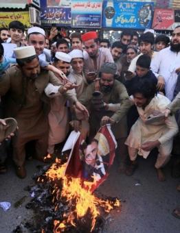 محتجون يحرقون صورة الرئيس الفرنسي خلال مظاهرة بمدينة بيشاور