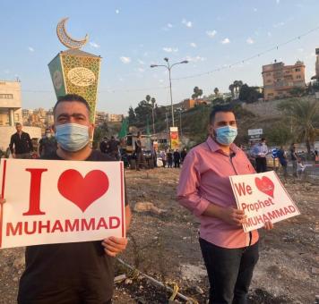 شبان يحملون لافتات نصرة للنبي محمد في ظل الإساءة إليه