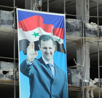 صورة بشار الأسد بين الدمار الذي أحدثته قصف ميليشياته
