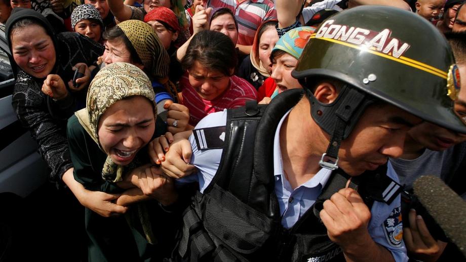 الشرطة الصينية أثناء اعتقال مسلمات.