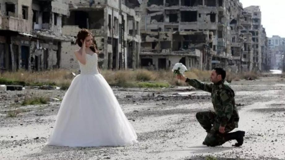 ضابط من ميليشيات الأسد مع عروسه وسط أنقاض مدينة حمص